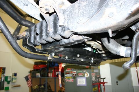 1995 Ford Bronco - The underside of a vehicle shows modifications to the suspension and drivetrain components.