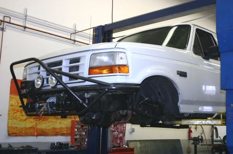 1995 Ford Bronco - A white 1995 Ford Bronco is shown on a lift, equipped with a winch and brush guard.