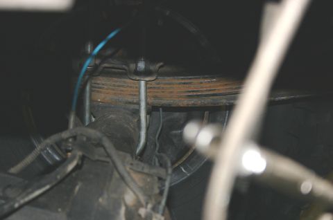 1995 Ford Bronco - Close-up of a vehicle's rear axle and suspension components, showing leaf springs and U-bolts.