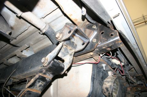 1995 Ford Bronco - Close-up view of a custom-welded bracket attached to the underside of a vehicle's frame.