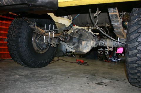 1995 Ford Bronco - Underside view of a vehicle's rear axle and suspension system, showing leaf springs and U-bolts.