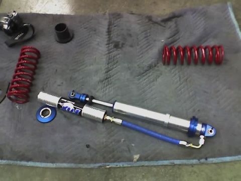1995 Ford Bronco - Fox Racing shock absorber and two red coil springs are displayed on a mat.