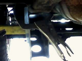1995 Ford Bronco - Close-up view of a vehicle's undercarriage, showing suspension components and a Supermotors logo.
