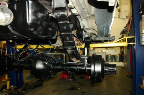 1995 Ford Bronco - Underside view of a vehicle's rear axle and suspension system, undergoing maintenance.