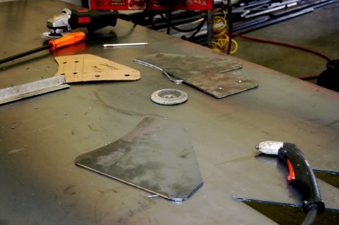 1995 Ford Bronco - Metal parts and tools laid out on a workbench for fabrication.