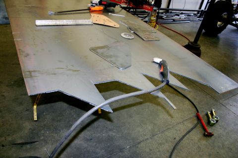 1995 Ford Bronco - Metal pieces are being cut and shaped on a large table, with a plasma cutter ready for use.