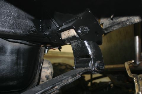 1995 Ford Bronco - Underside view of a vehicle's suspension bracket and leaf spring assembly.