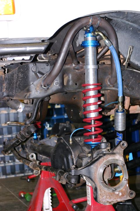 1995 Ford Bronco - Close-up of a vehicle's front suspension system, showing a shock absorber and related components.
