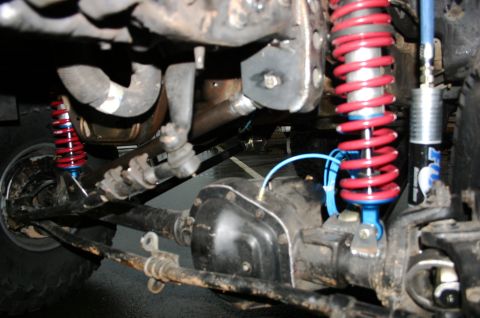 1995 Ford Bronco - Close-up view of the front suspension and differential, red Fox coilovers.