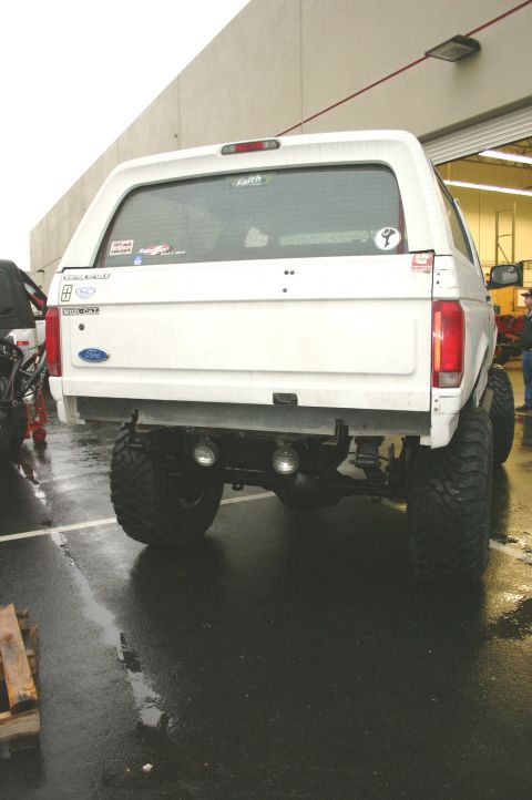 1995 Ford Bronco - Rear view of a lifted 1995 Ford Bronco with large off-road tires and dual exhaust pipes.
