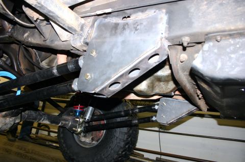 1995 Ford Bronco - Custom suspension parts are bolted to the vehicle frame, showing linkages and a shock absorber.