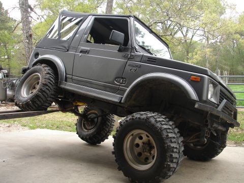 1987 Ford Bronco - This modified SUV is shown at an angle, with its front wheels on a ramp and its rear wheels on the ground.