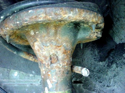 1973 Ford Ranchero - Close-up of a corroded vehicle suspension part, showing significant rust and attached hoses.
