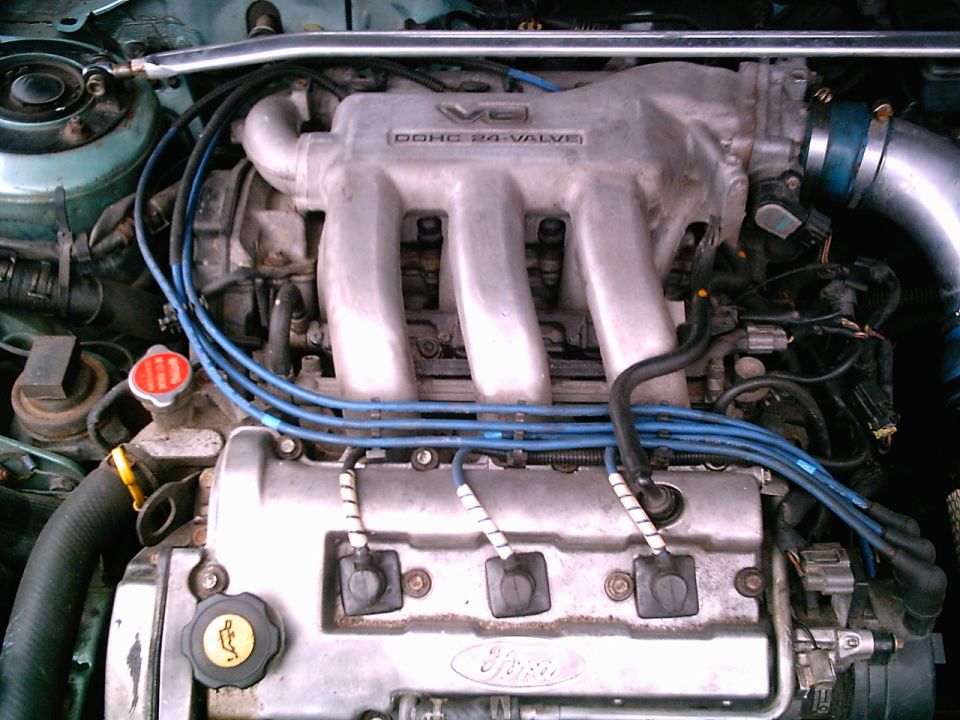 Close-up of a Ford V6 DOHC 24-valve engine with blue spark plug wires