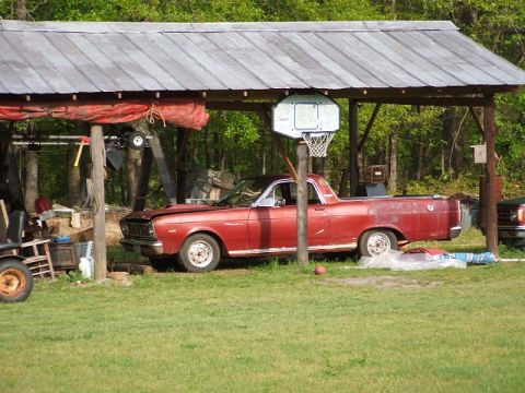 1966 Ford Ranchero - Red 1966 Ford Ranchero sits under a carport with its hood open, a basketball hoop mounted nearby.