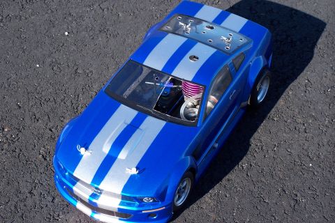 1994 Ford Bronco - This remote control car features a vibrant blue paint job with silver racing stripes and a visible engine compartment.