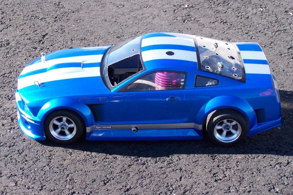 blue remote control car with white stripes, has a purple engine part visible inside