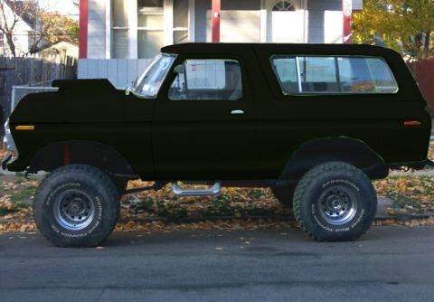 1978 Ford Bronco - A black 1978 Ford Bronco with a hood scoop and large tires is parked on a street.
