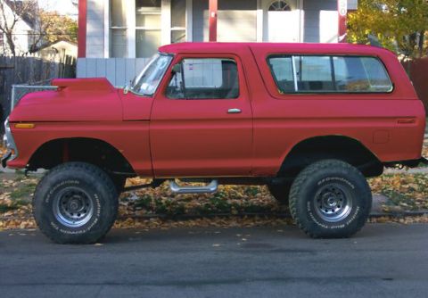 1978 Ford Bronco - This red SUV has a prominent hood scoop and is lifted with large off-road tires.
