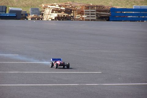 1994 Ford Bronco - A remote control car is seen on a paved surface, with stacks of wood in the background.