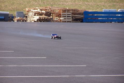 1994 Ford Bronco - A remote control car is seen driving on a paved surface, with a plume of smoke trailing behind it.