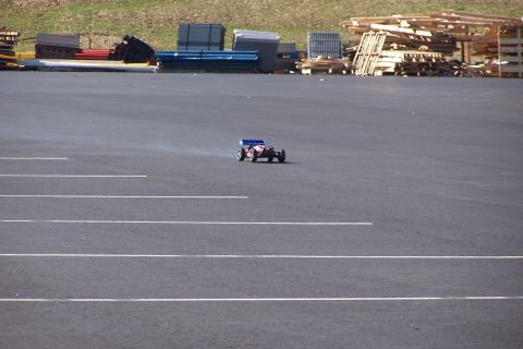 1994 Ford Bronco - A remote control buggy is seen on an empty asphalt lot with stacks of materials in the background.