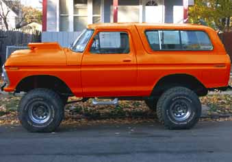1978 Ford Bronco - This lifted 1978 Ford Bronco features a prominent hood scoop and is presented in a vibrant orange finish.