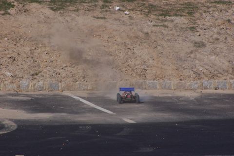 1994 Ford Bronco - A remote control buggy speeds along a track, leaving a trail of dust behind it.