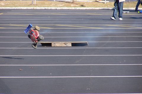 1994 Ford Bronco - RC car flips while going over a ramp on a paved track.