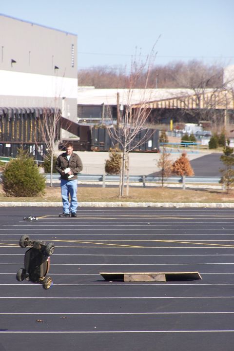 1994 Ford Bronco - A person operates a remote control car on a track, with another car overturned nearby.