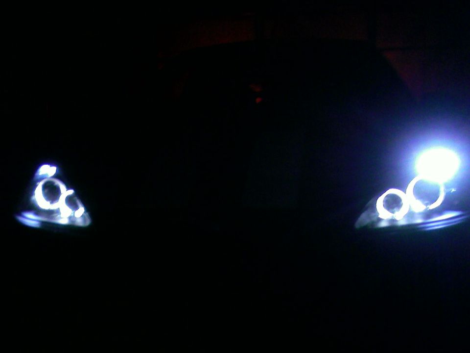 Car headlights with halo rings, one on the left and one on the right, illuminated in the dark