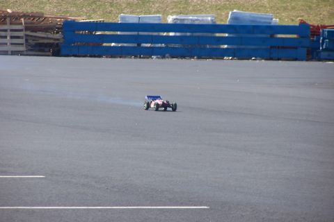 1994 Ford Bronco - A remote control car speeds across an asphalt track, leaving a trail of smoke.