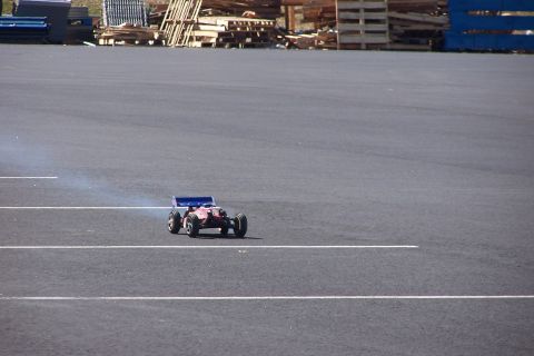 1994 Ford Bronco - A remote control buggy is seen on a paved surface, emitting a trail of smoke.