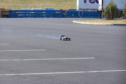1994 Ford Bronco - A remote control buggy is seen driving on a paved surface, emitting a trail of smoke.
