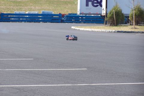 1994 Ford Bronco - A remote control buggy is seen on an asphalt surface with parking lines and a FedEx truck in the background.