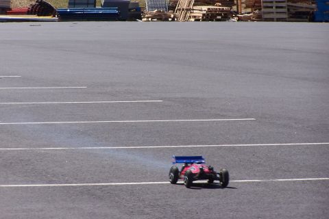 1994 Ford Bronco - A remote control car is seen on a paved surface with parking lot lines.
