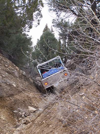 1986 Ford Bronco - This 1986 Ford Bronco is shown off-roading on a challenging, steep, and wooded incline.
