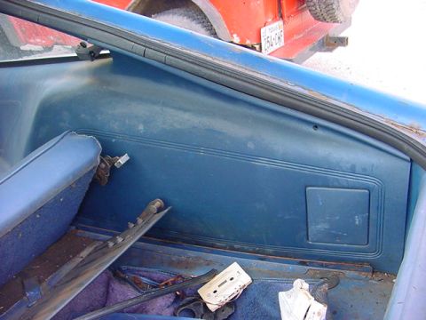1978 Ford Mustang II - The interior of a blue car is shown, with a red vehicle visible outside. A cassette tape lies on the floor.