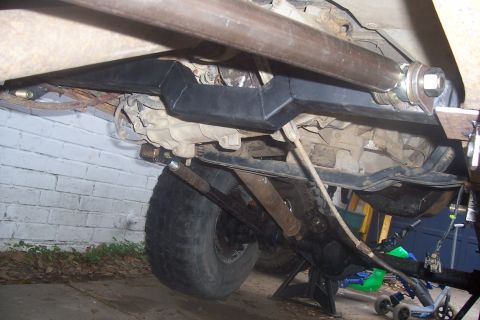 1987 Ford Bronco - The underside of a vehicle is shown, focusing on the drivetrain and suspension components.
