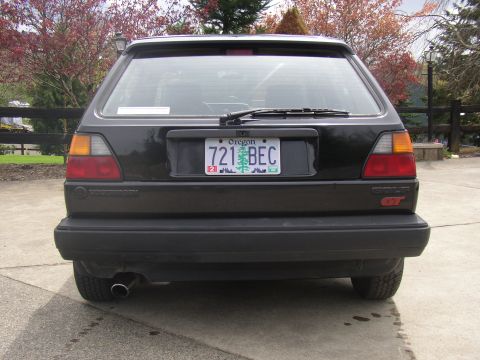 1987 Volkswagen Golf - Rear view of a black 1987 Volkswagen Golf GT, showing its distinctive taillights and GT badging.