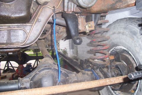 1987 Ford Bronco - Close-up view of the undercarriage of a vehicle, showing suspension and drivetrain parts.