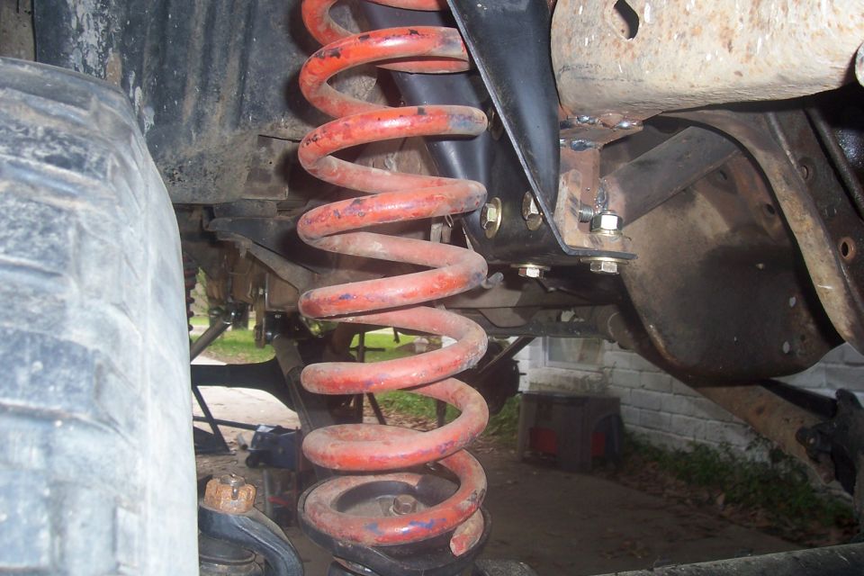 Close-up of red suspension coil and vehicle frame