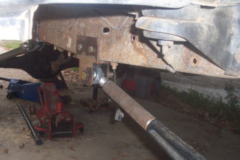 1987 Ford Bronco - Vehicle frame and suspension components are visible, supported by hydraulic jacks.