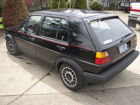 1987 Volkswagen Golf - A black Volkswagen Golf is shown from the rear three-quarter view, parked on a concrete driveway.