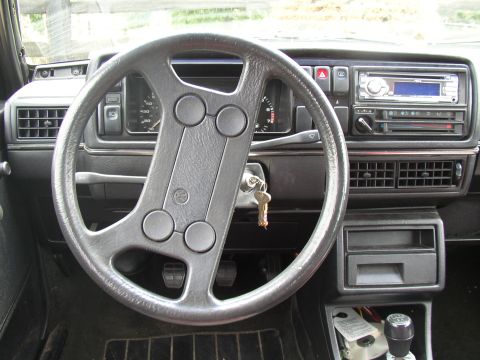 1987 Volkswagen Golf - The interior of a 1987 Volkswagen Golf, its dashboard, steering wheel, and center console.