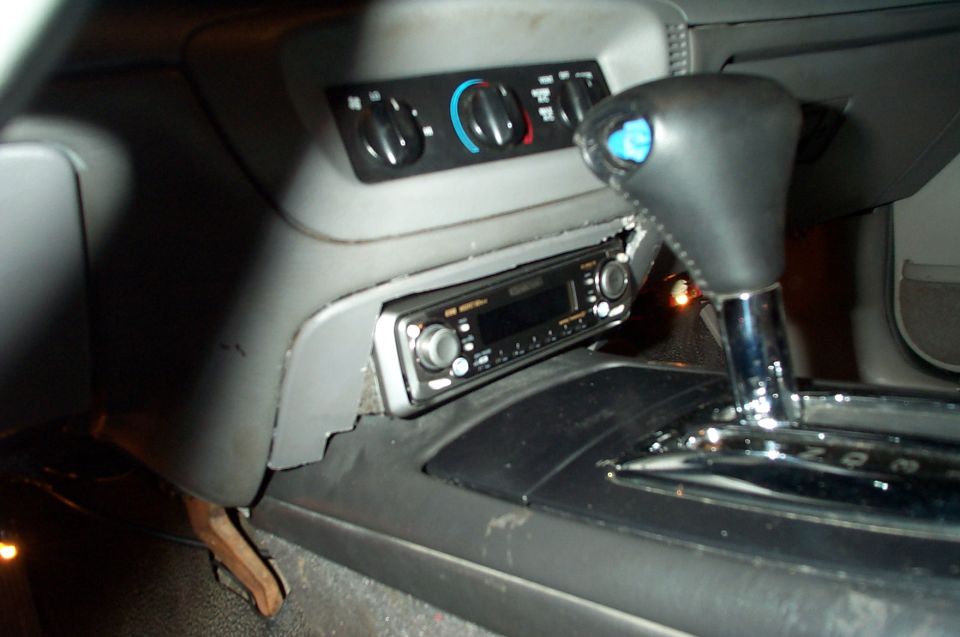 Car interior with aftermarket radio, HVAC knobs, and chrome auto shifter