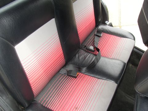 1987 Volkswagen Golf - Rear interior seats feature a distinctive black and pink striped fabric pattern with black leatherette accents.