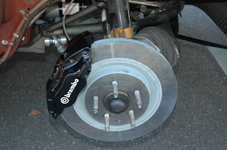 Black Brembo brake caliper with white lettering on a vented rotor