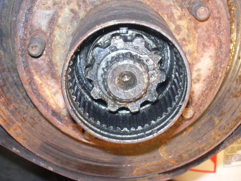 1991 Ford Bronco - Close-up view of a rusty wheel hub assembly, showing the internal gears and locking mechanism.