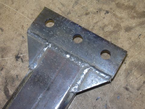 1991 Ford Bronco - Close-up of a welded metal bracket with three holes, likely a vehicle part.